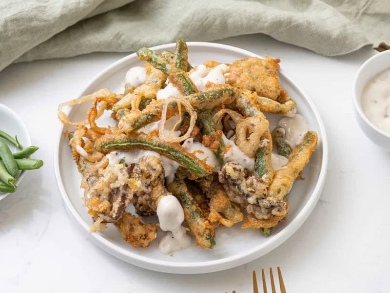 image 248 88 - Here's a way to flip the script and turn the vegetable side into the most sought-after, craved part of the Thanksgiving meal. Fried Green Bean Casserole transforms mushrooms, shallots, and of course green beans into crispy, salty treats with fresh and tender interiors. Slathered in a deeply savory and rich gravy, Fried Green Bean Casserole has an addictive taste that rings with holiday cheer. It takes your vegetables from simple greens to greatness.