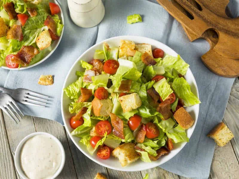 image 249 28 - Inspired by BLT lovers everywhere, the BLT Salad is sure to be a crowd-pleaser. Enjoy the delightful flavors of warm bacon, ripe tomatoes, and tangy dressing in this delicious recipe. There are even fresh croutons for the full homemade taste! The irresistible BLT Salad is perfect for your next picnic, family gathering, or summertime lunch.