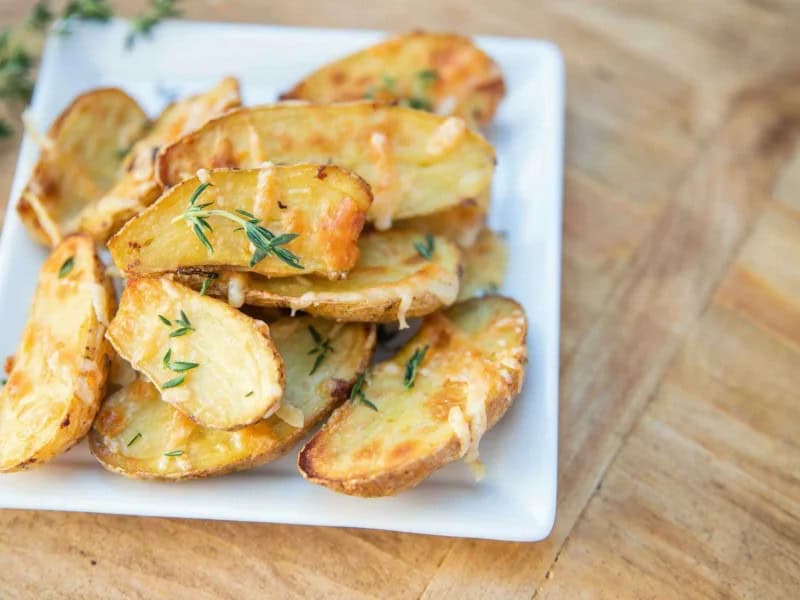 image 249 77 - Everyone, including the cooks, love these Easy Baked Fingerling Potatoes! It's a speedy side with a fluffy interior, crispy exterior, and savory seasoning. Add in a sharp bite of parmesan and you have a dish that might just overshadow everything else on the plate! All you need is 30 minutes to make these perfectly peppy potatoes!