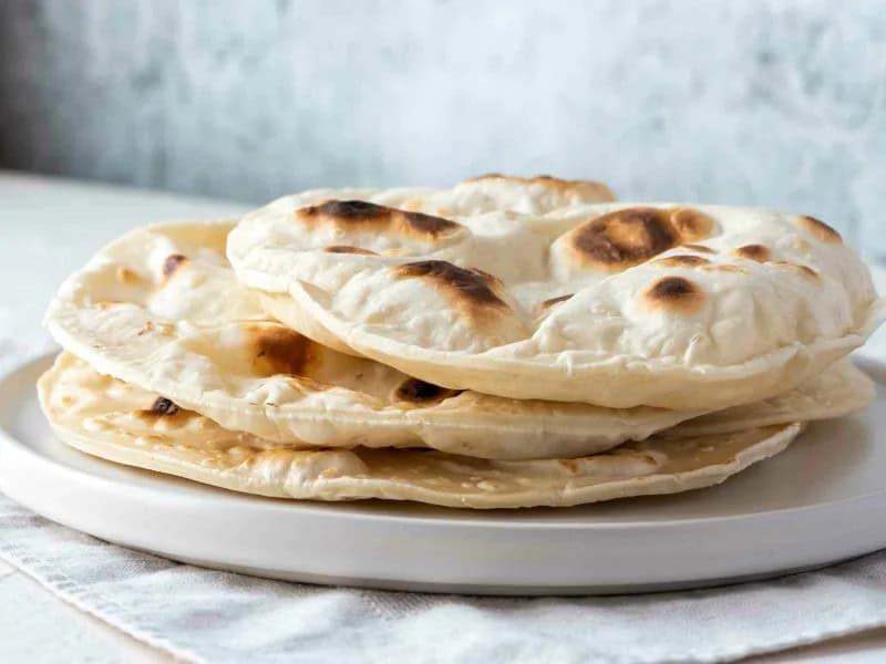 image 817 - Naan is a popular staple served with Indian meals; it’s perfectly designed for scooping uptick sauces or mopping up the last morsels of flavor. Homemade Naan Bread is fluffy, flavorful, and surprisingly easy to make in your own kitchen. Homemade Naan Bread is perfect as a snack with a pat of butter or as a side for tasty meat meals or with soups!